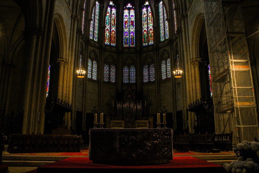 Vista frontal del altar de la catedral de Montpellier, con el órgano y vitrales iluminando el coro.