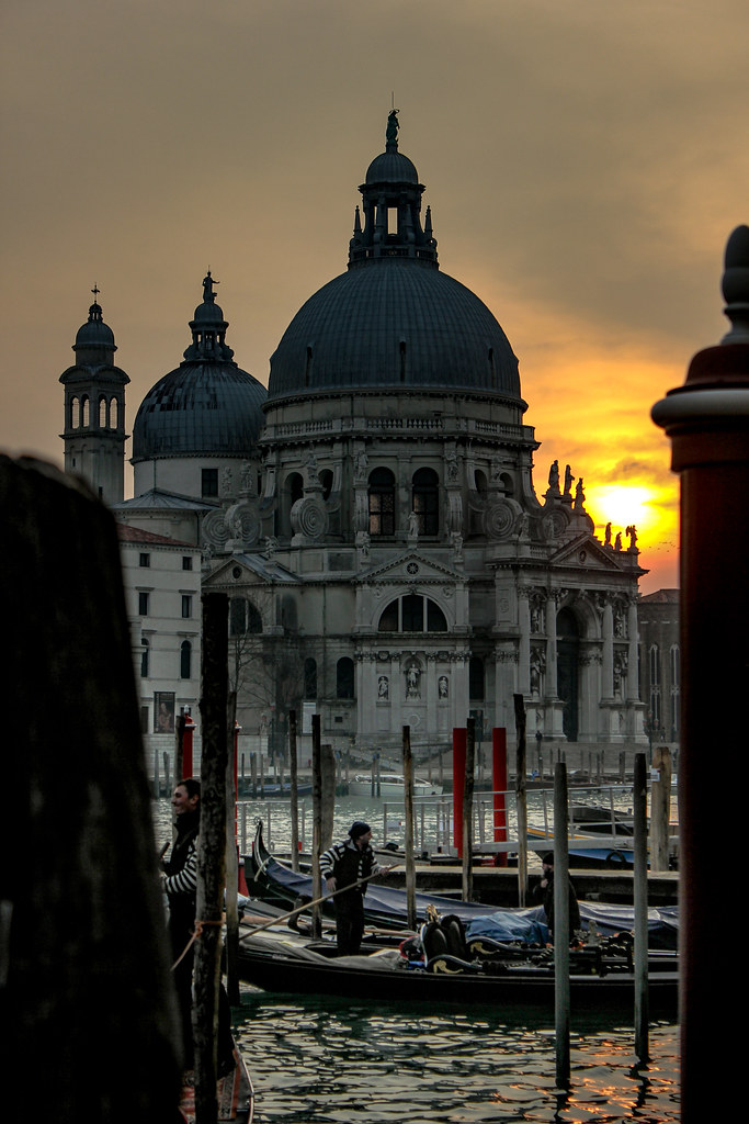 Atardecer detrás de la Basílica de Santa Maria della Salute en Venecia con góndolas en primer plano.