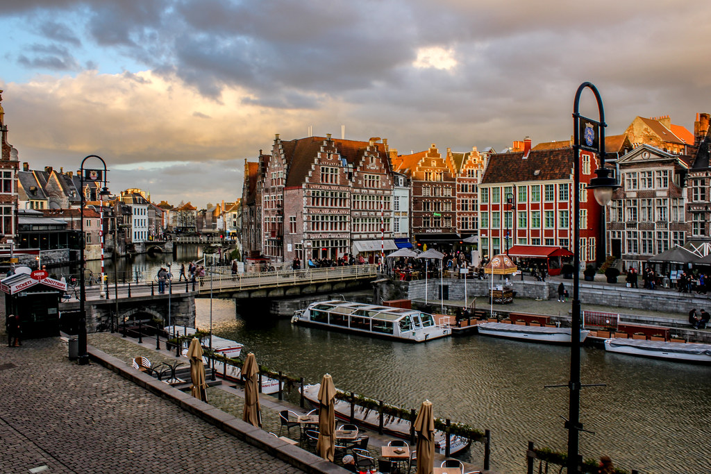 Atardecer en el canal de Gante con casas de fachadas coloridas y cielo nuboso.