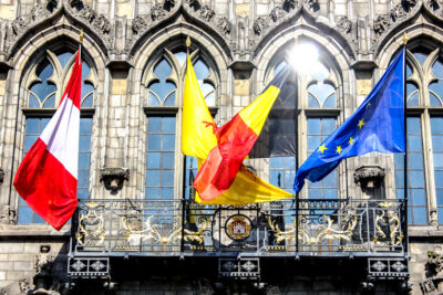 Banderas de Mons, Valonia, Bélgica y la Unión Europea ondeando en la fachada del Ayuntamiento de Mons, Bélgica.