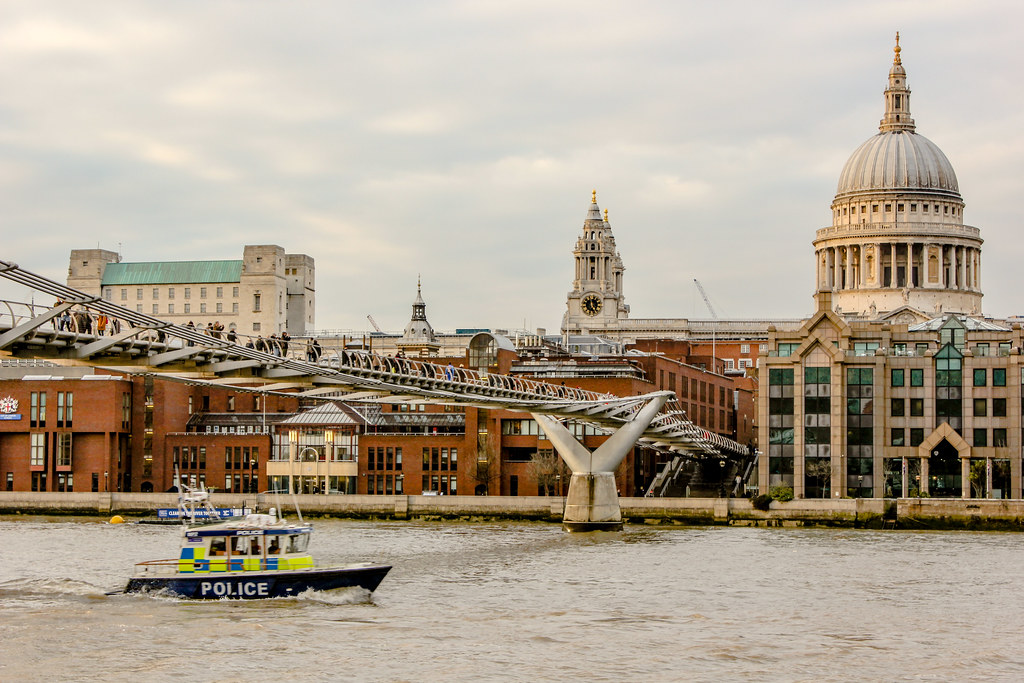 Barco de policía en el Támesis con el Puente del Milenio y la Catedral de San Pablo de fondo en Londres.