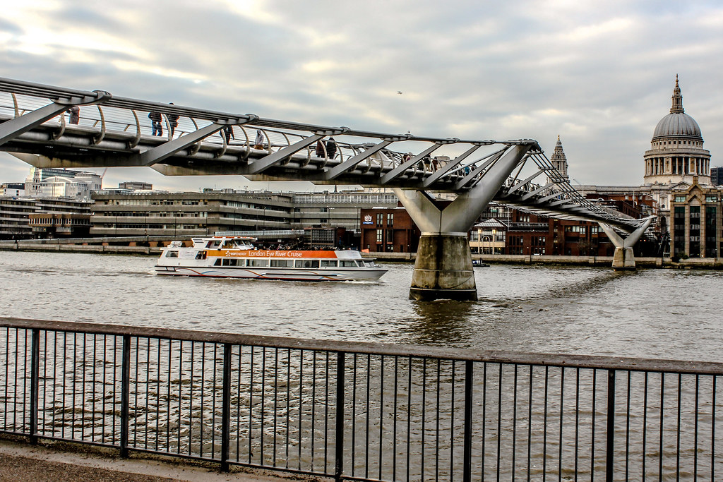 Barco turístico pasando bajo el Puente del Milenio con la Catedral de San Pablo de fondo en Londres.