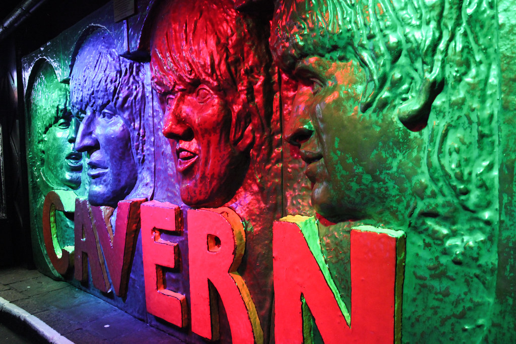 Relieve de los Beatles en la entrada del Cavern Club iluminado con luces de colores.