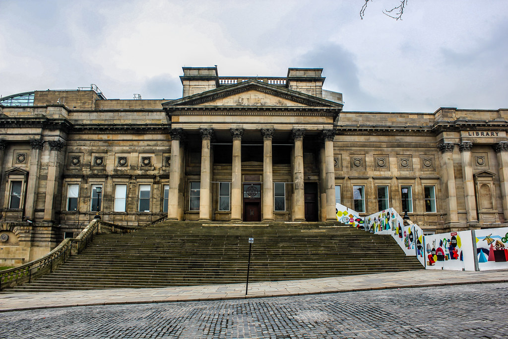 Biblioteca Central de Liverpool con escalinatas y exposición artística.