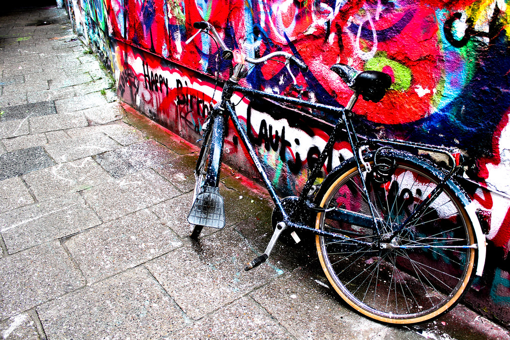 Bicicleta pintada con gotas de pintura aparcada en Werregarenstraat, la callejuela de arte callejero en Gante.