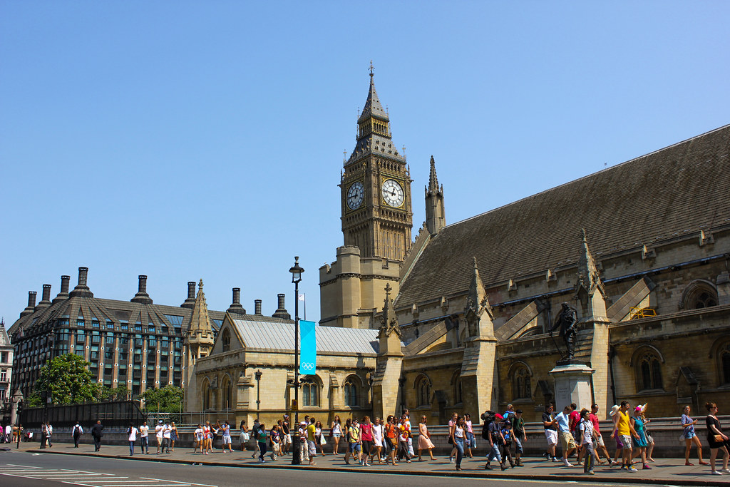 Vista diurna del Big Ben y el Palacio de Westminster con turistas paseando.