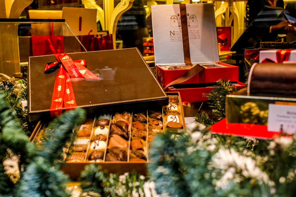 Caja de bombones con lazo rojo en escaparate navideño de las Galerías Saint-Hubert.