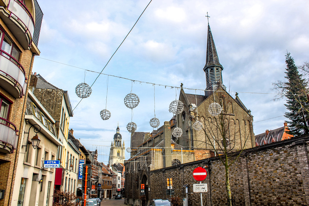 Calle adornada con esferas decorativas en Halle, Bélgica, con la iglesia de fondo.
