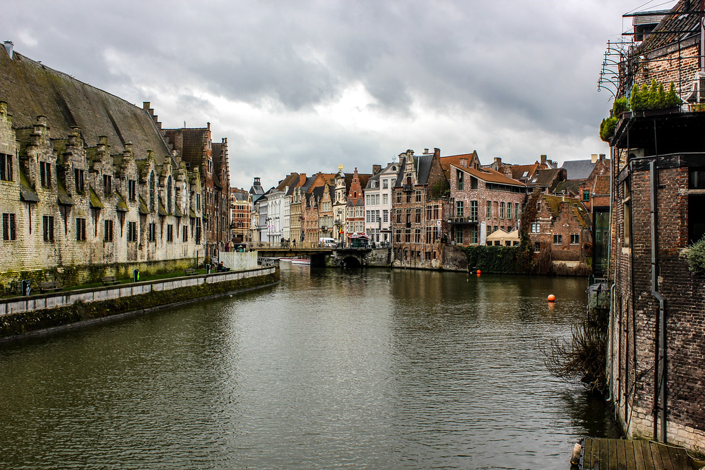 Vista del canal de Gante con edificios históricos y cielo nublado.