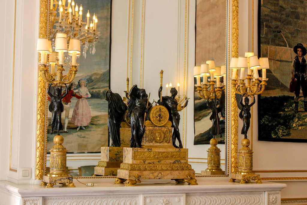 Candelabros dorados sobre una chimenea con esculturas y pinturas en el Palacio Real de Bruselas.