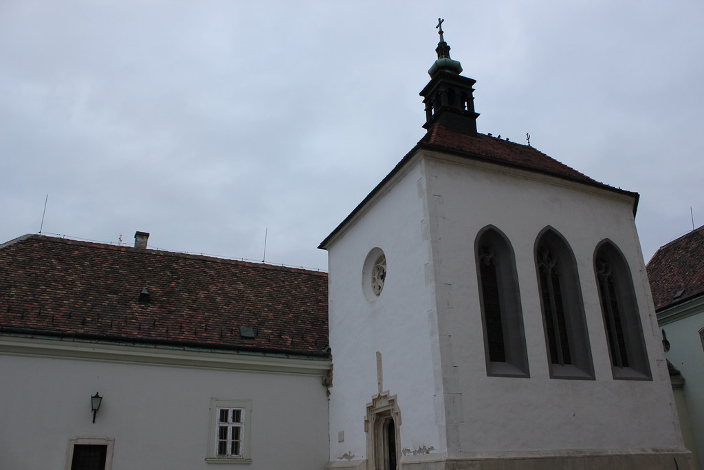 Capilla de Santa Ana en Székesfehérvár con tejados de tejas y fachada blanca.
