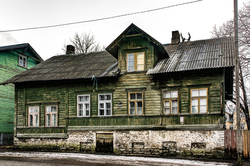 Casa tradicional de madera en el barrio de Kalamaja, Tallin, con tejado de metal y paredes envejecidas.