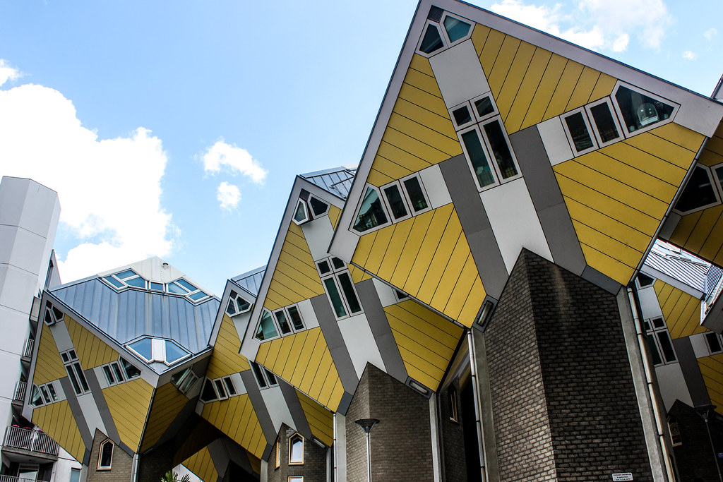 Casas Cubo amarillas de Rotterdam bajo un cielo azul con nubes.