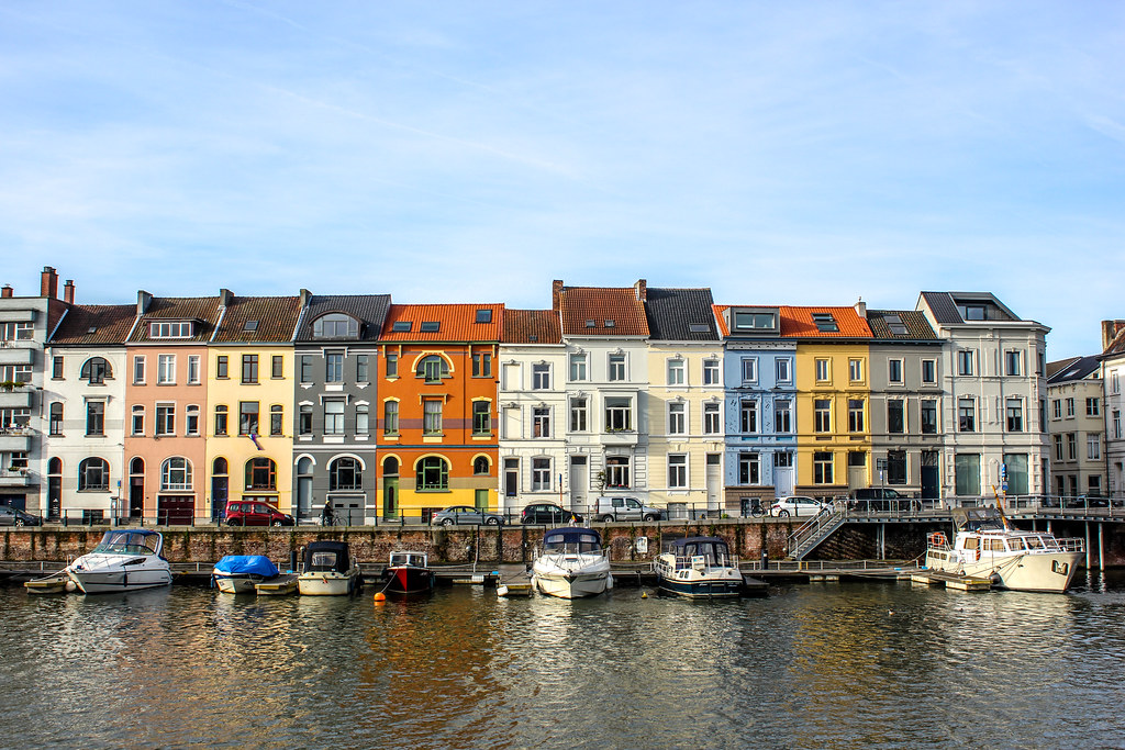 Casas coloridas frente al río con barcos amarrados en Gante, Bélgica.