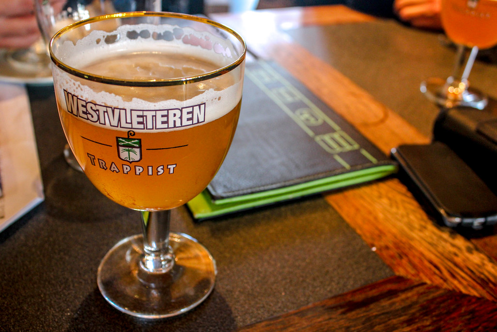 Copa de cerveza rubia Westvleteren Blond en un establecimiento con menú visible.