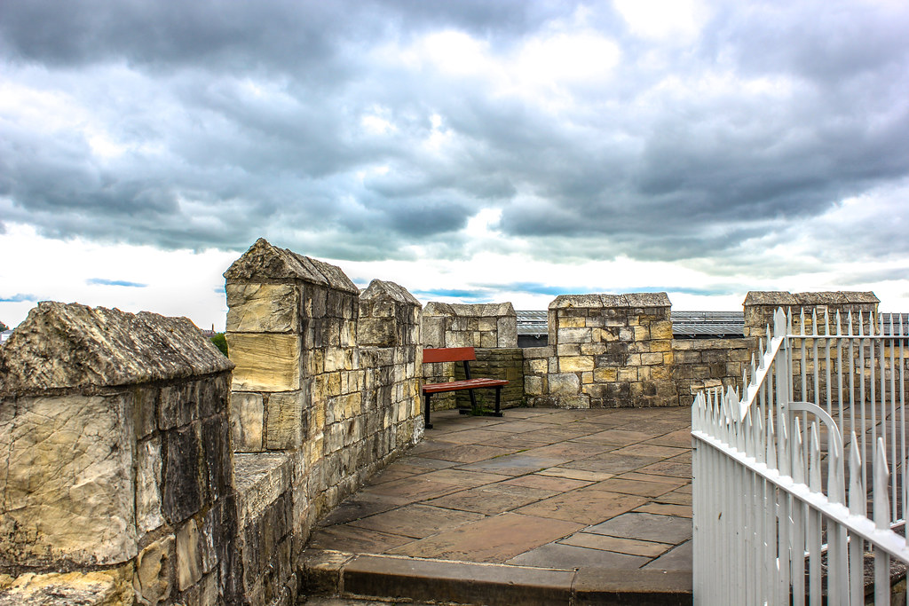 Área de descanso en la muralla de York con cielo nublado de fondo.