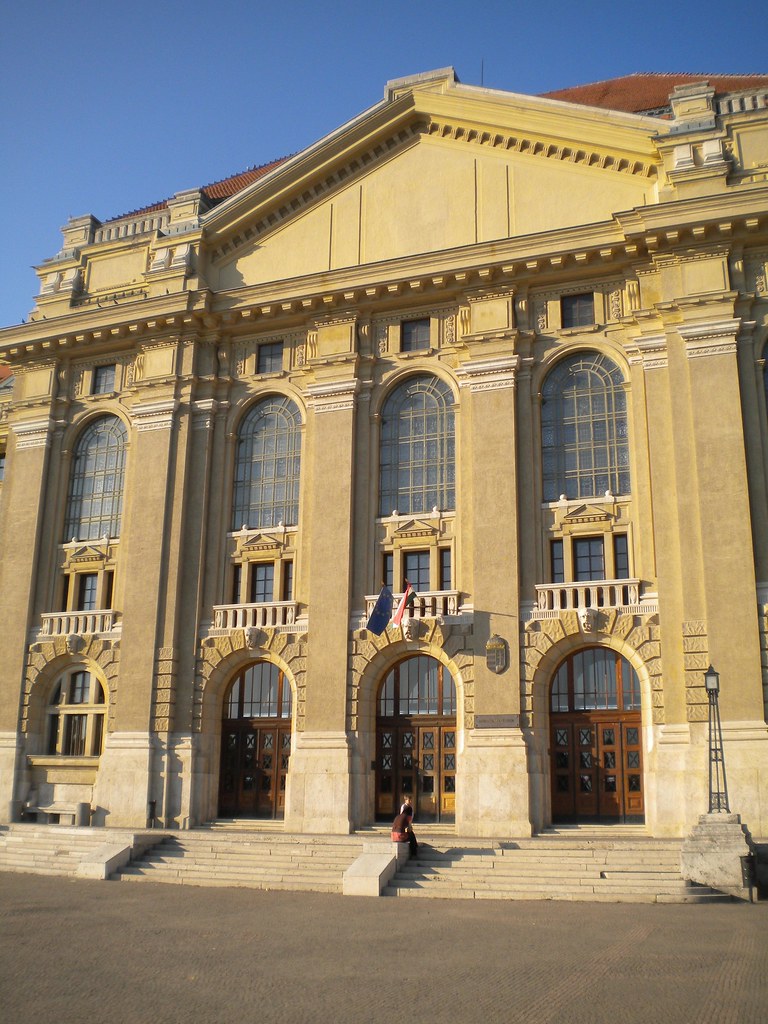 Entrada principal de la Universidad de Debrecen con grandes puertas de madera.