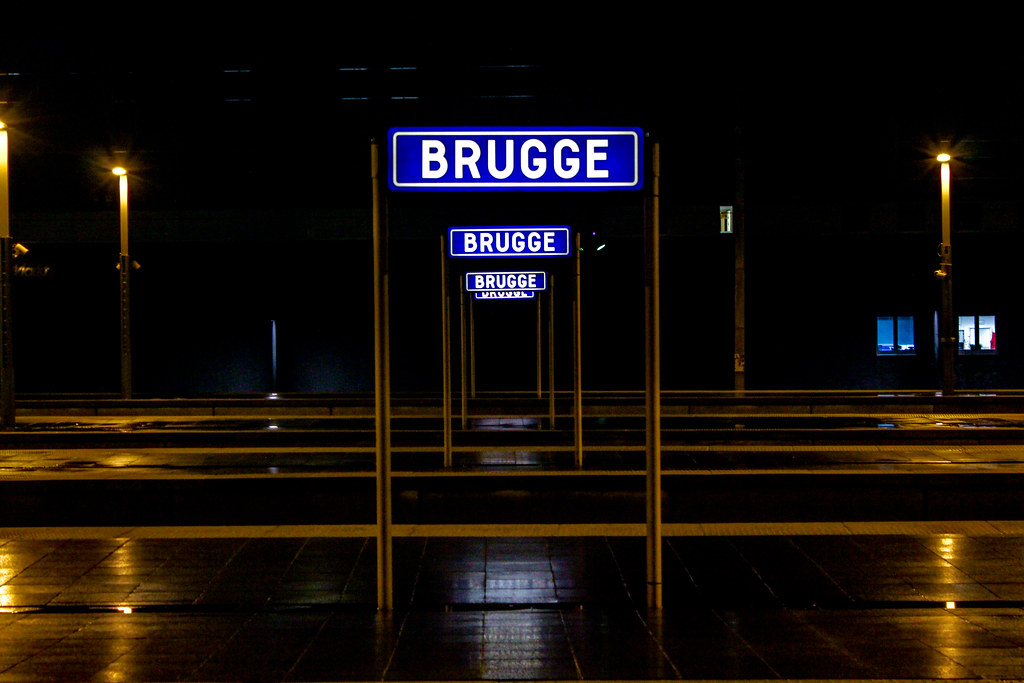Cartel iluminado de la estación de tren de Brujas de noche.