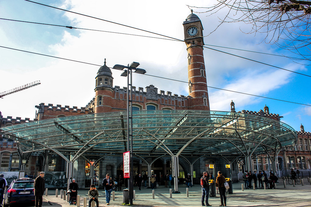 Estación de tren Gent-Sint-Pieters con estructura de cristal y torre de reloj en Gante.