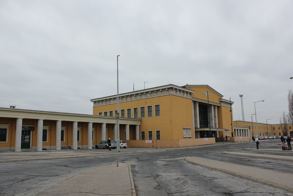 Estación de tren de Székesfehérvár con fachada amarilla y columnas.