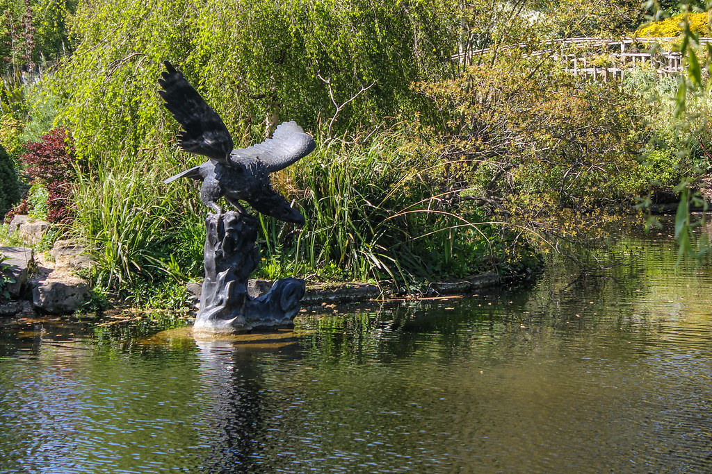 Estatua de águila aterrizando sobre una roca en el estanque del Queen Mary's Gardens, Regent's Park.