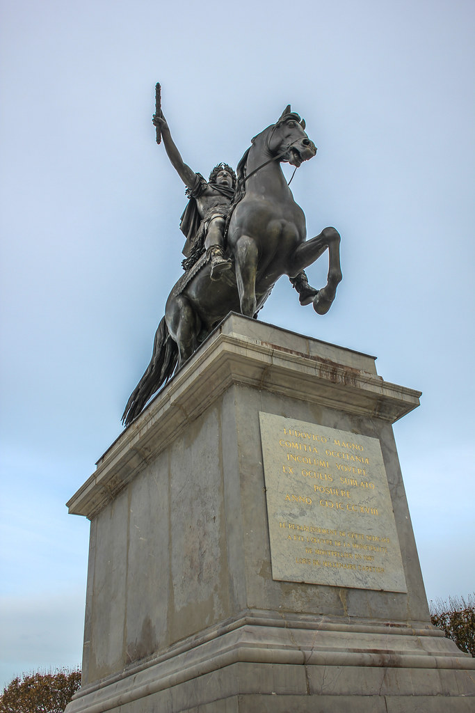 Estatua ecuestre de Luis XIV en la Plaza Real del Peyrou en Montpellier bajo un cielo nublado.