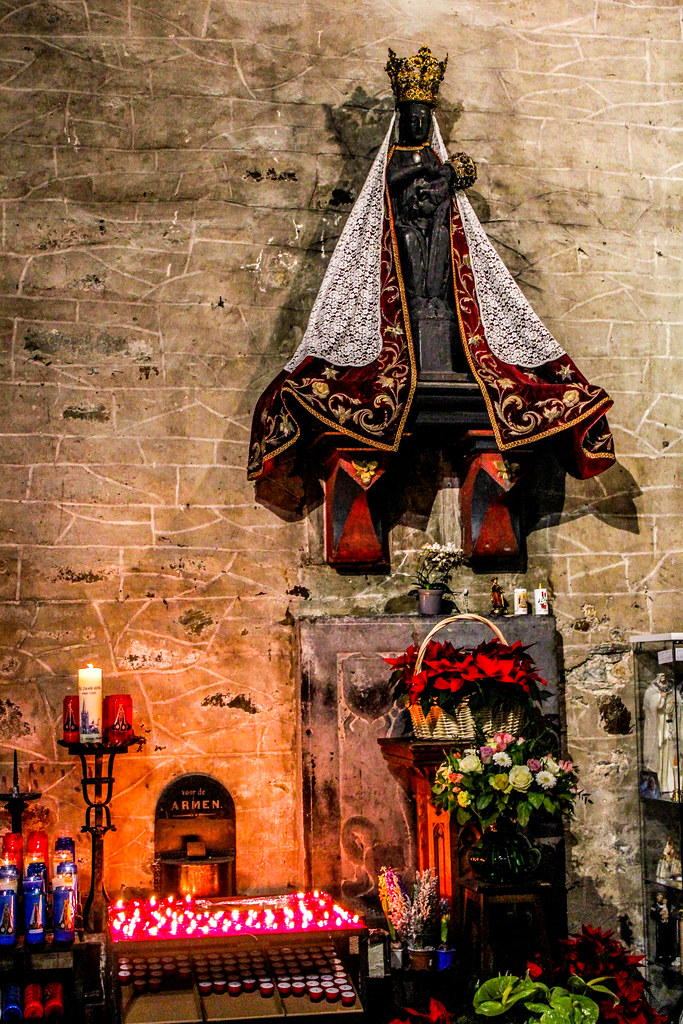 Estatua de la Virgen con el Niño iluminada por velas en el interior de la Basílica de San Martín en Halle.
