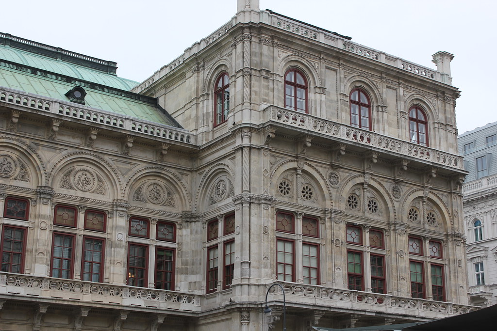 Fachada detallada de la Ópera Estatal de Viena con arquitectura renacentista y ventanas arqueadas.