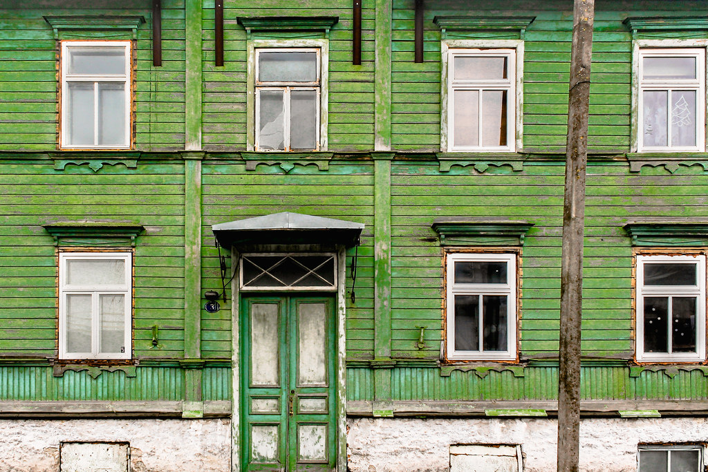 Fachada de casa de madera verde desgastada en Kalamaja, Tallin.