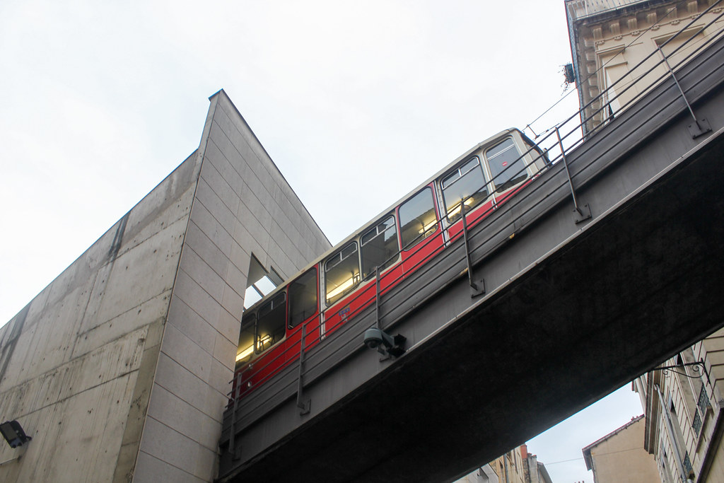 Funicular rojo saliendo de la estación en la arquitectura moderna de Lyon.