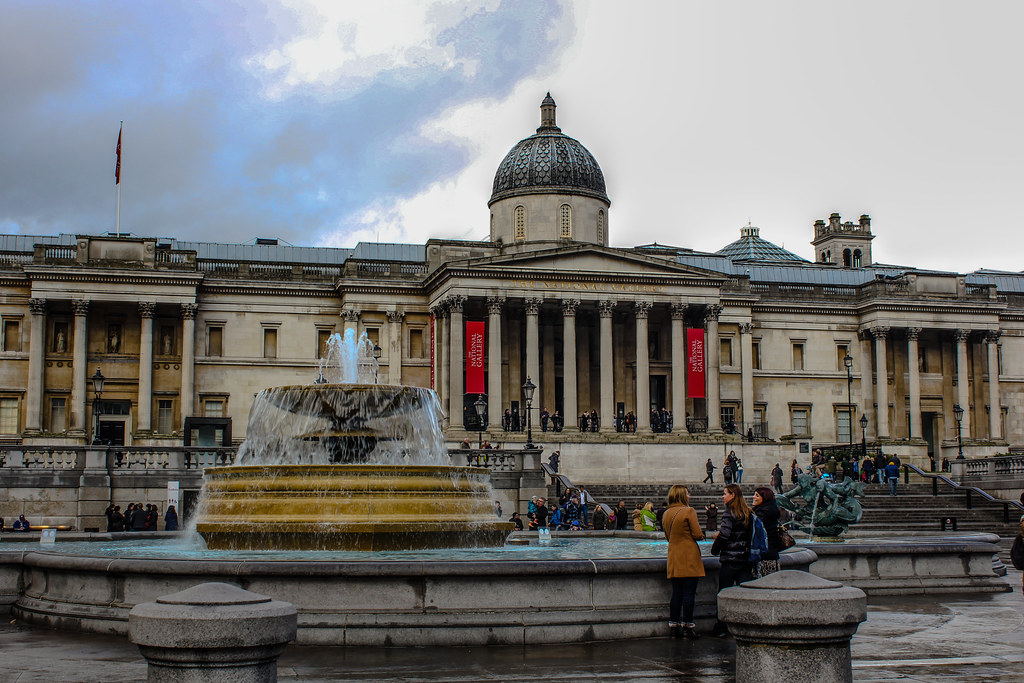 Fachada de la Galería Nacional en Trafalgar Square con fuente en primer plano.