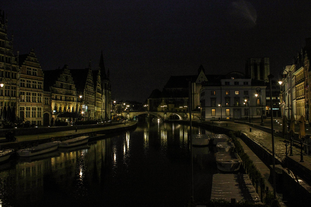 Nocturna del canal en Gante con iluminación reflejada y arquitectura histórica.