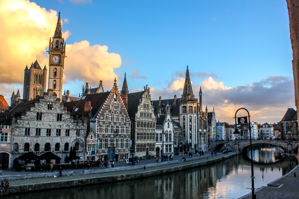 Panorama del horizonte de Gante con la torre del reloj y arquitectura tradicional al atardecer.