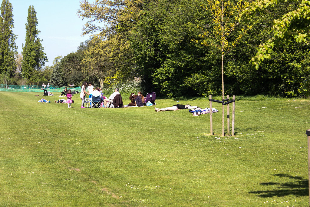 Gente disfrutando del tiempo al aire libre en un área de césped en Regent's Park, Londres, en un día soleado.