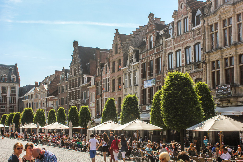 Gente disfrutando en terrazas en la animada Oude Markt de Lovaina, Bélgica.