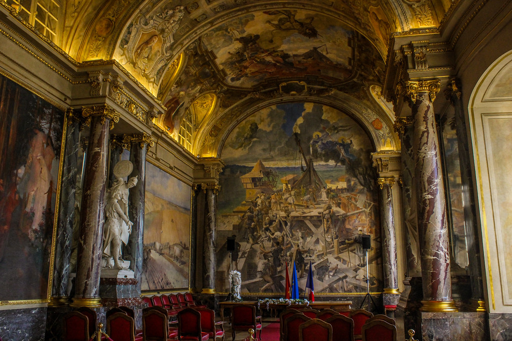 Interior de la Sala de los Ilustres con murales y columnas de mármol en el Capitolio de Toulouse.