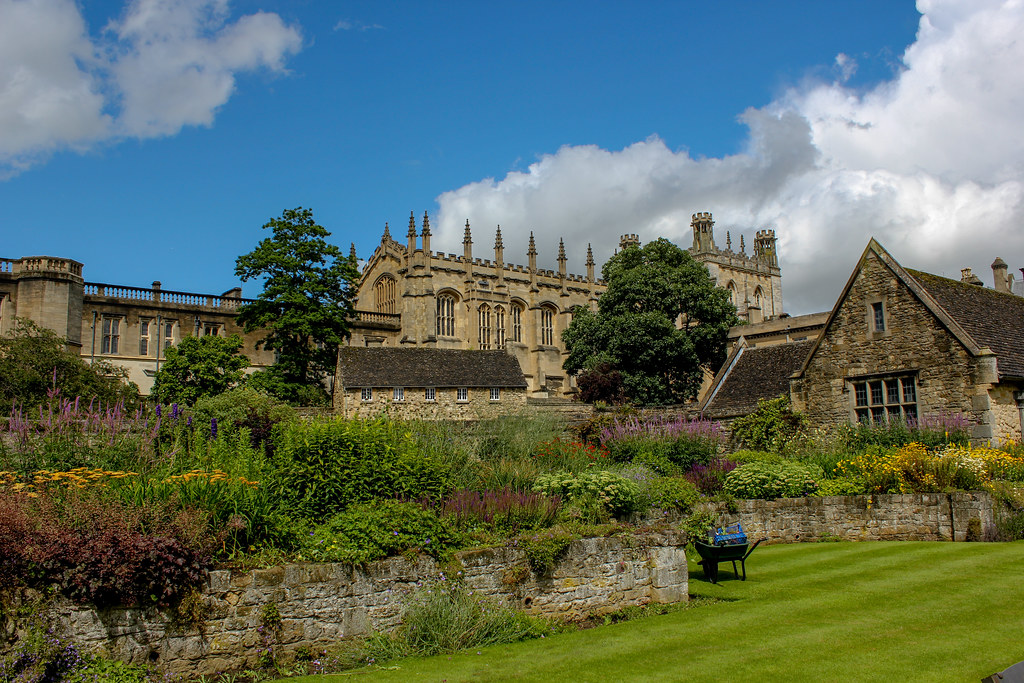 Jardín florido con edificios de Christ Church College de Oxford al fondo.