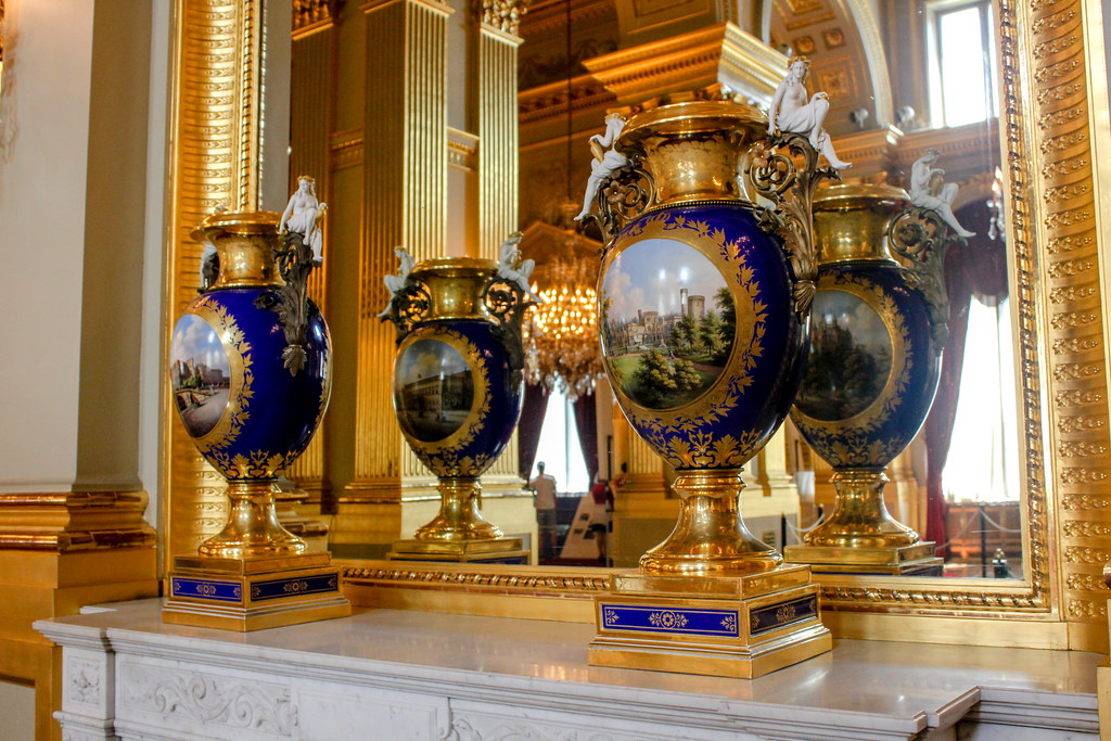 Jarrones ornamentales azules y dorados con motivos paisajísticos en el Palacio Real de Bruselas.