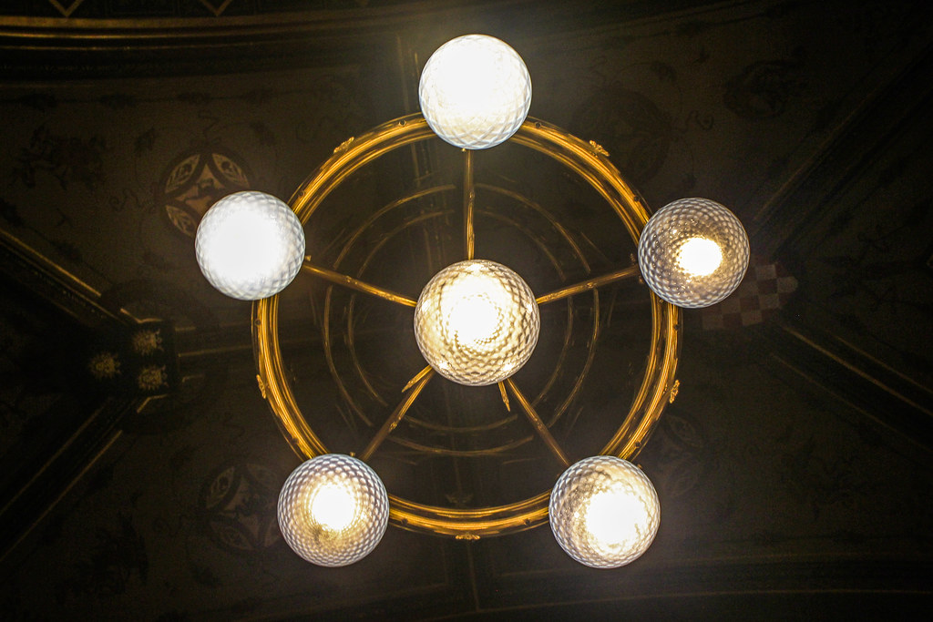 Lámpara de araña geométrica colgando de un techo ornamentado en el Parlamento de Budapest.