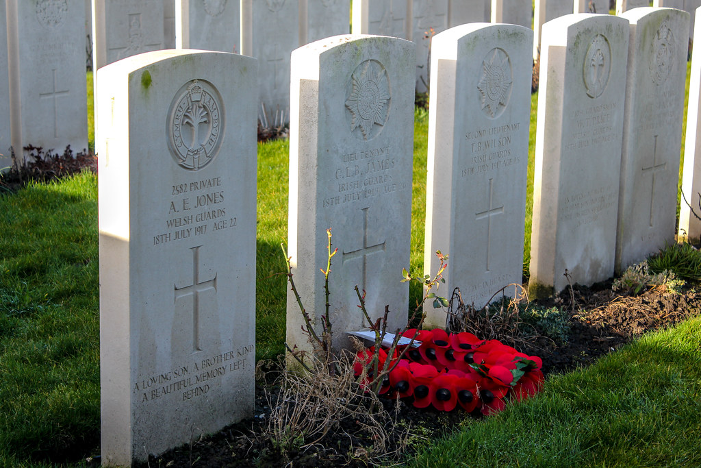 Lápidas en el Cementerio de Guerra en Poperinge, Bélgica, con coronas de amapolas rojas.