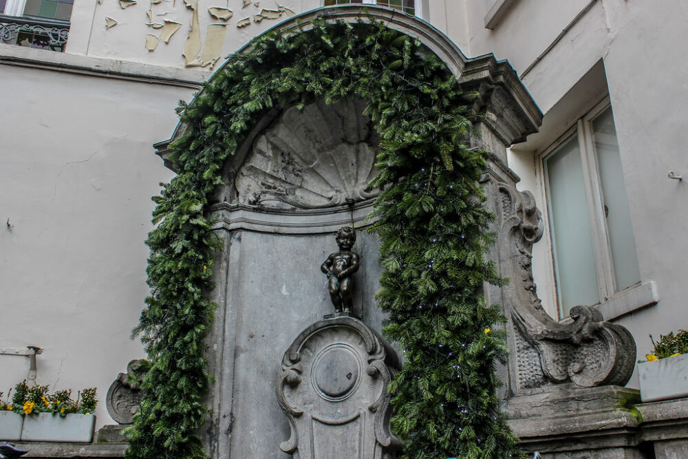 Estatua de Manneken Pis rodeada de hiedra en Bruselas.