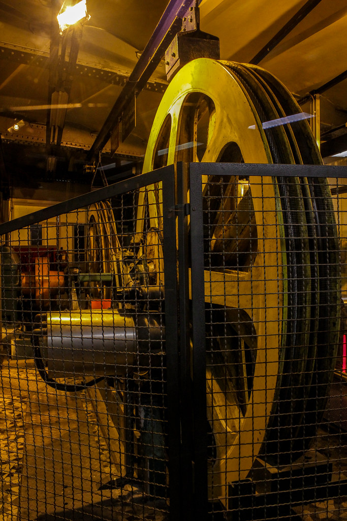 Maquinaria del funicular de Lyon con grandes poleas detrás de una valla de seguridad.