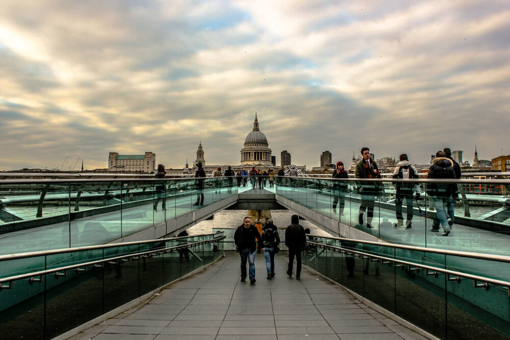 Vista del Millenium Bridge con transeúntes y la Catedral de San Pablo al fondo en Londres.