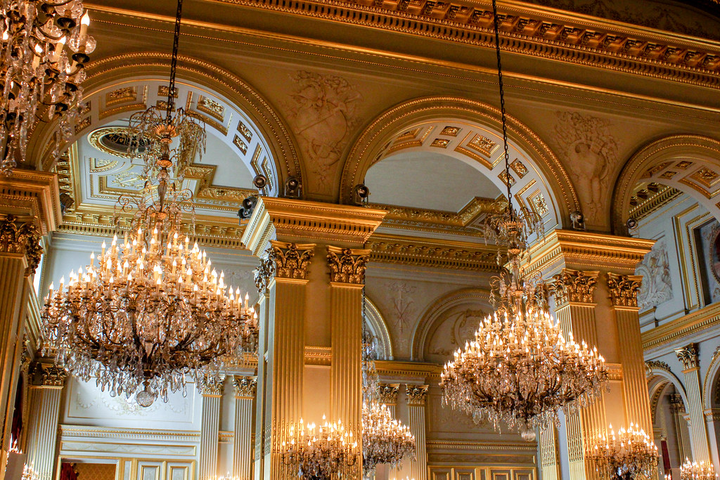 Múltiples candelabros de cristal iluminando el techo decorado del Palacio Real de Bruselas.