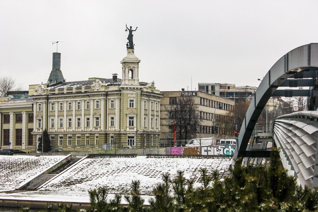 Museo de Energía y Tecnología con estatua en el techo y nieve en el suelo, Vilna, Lituania.