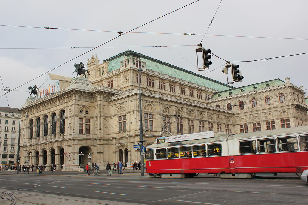 Ópera Estatal de Viena con tranvía rojo en primer plano.
