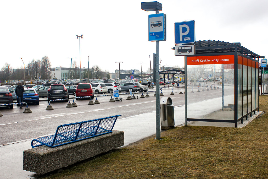 Parada de autobús para el servicio del Aeropuerto de Tallin al centro de la ciudad con aparcamiento al fondo.