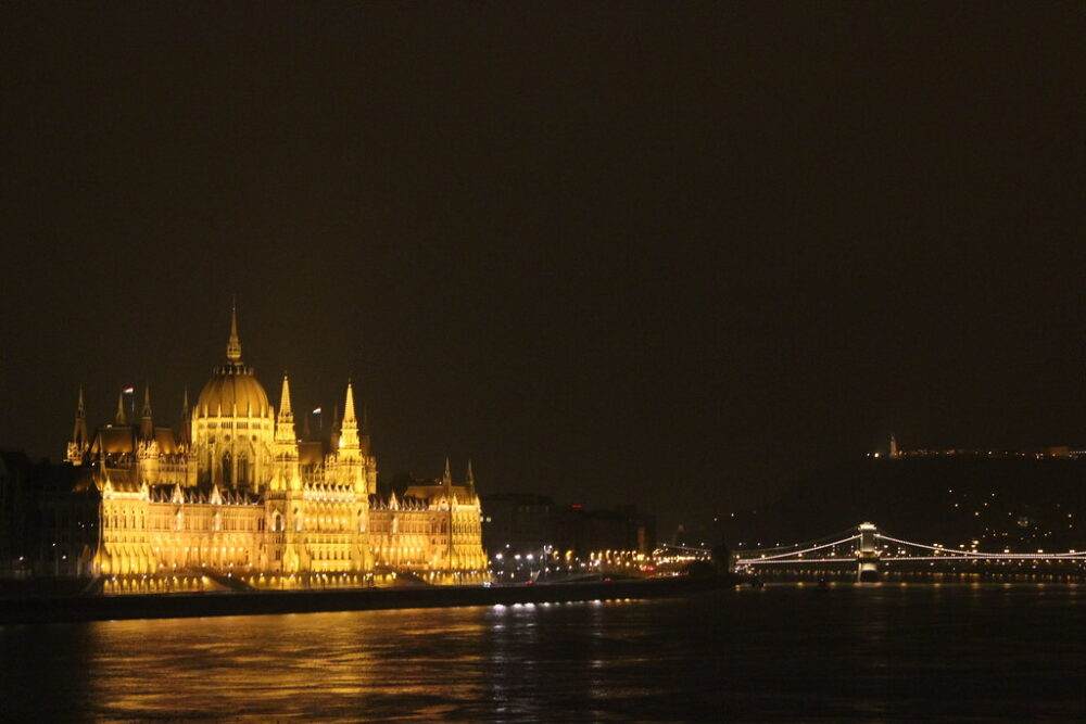 Vista nocturna del Parlamento de Budapest y el Puente de las Cadenas iluminados.