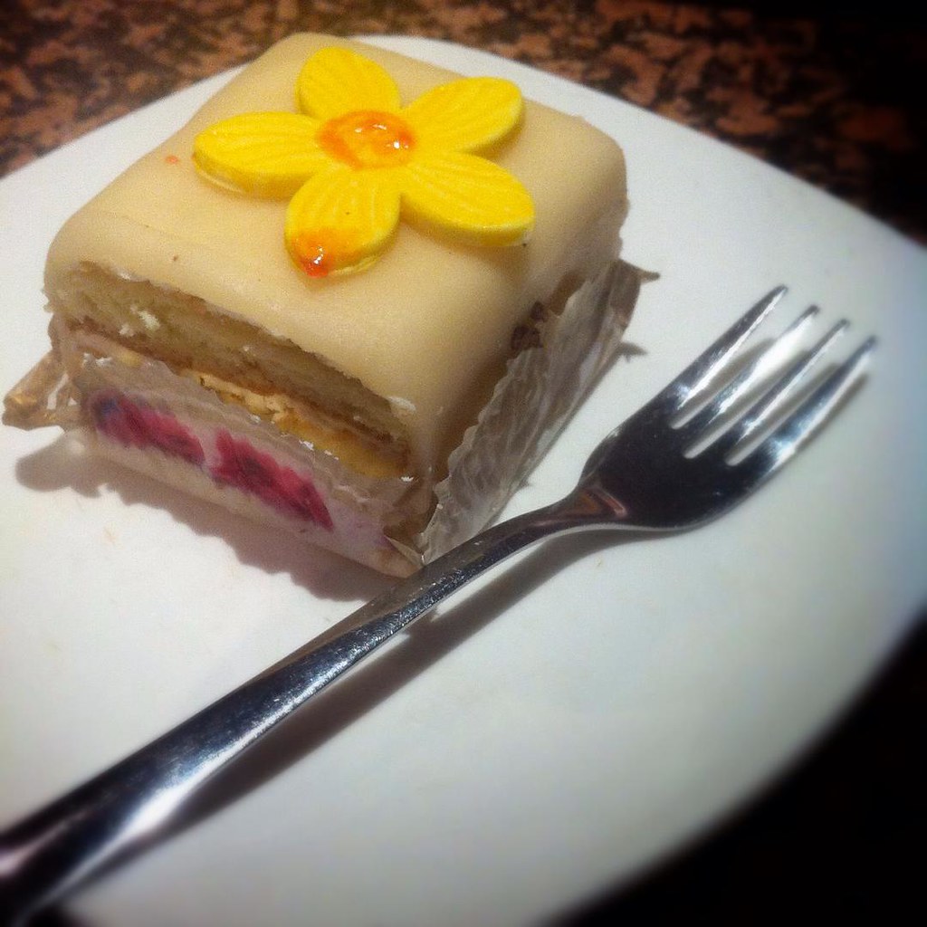 Pastel de mazapán con flor amarilla decorativa en el Reval Cafe.