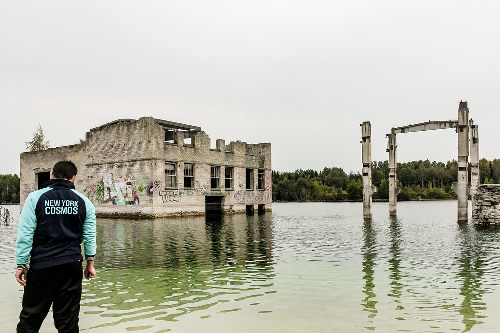 Mi amigo y conductor Coco mirando hacia una estructura abandonada y grafitis en el lago de Rummu, Estonia.